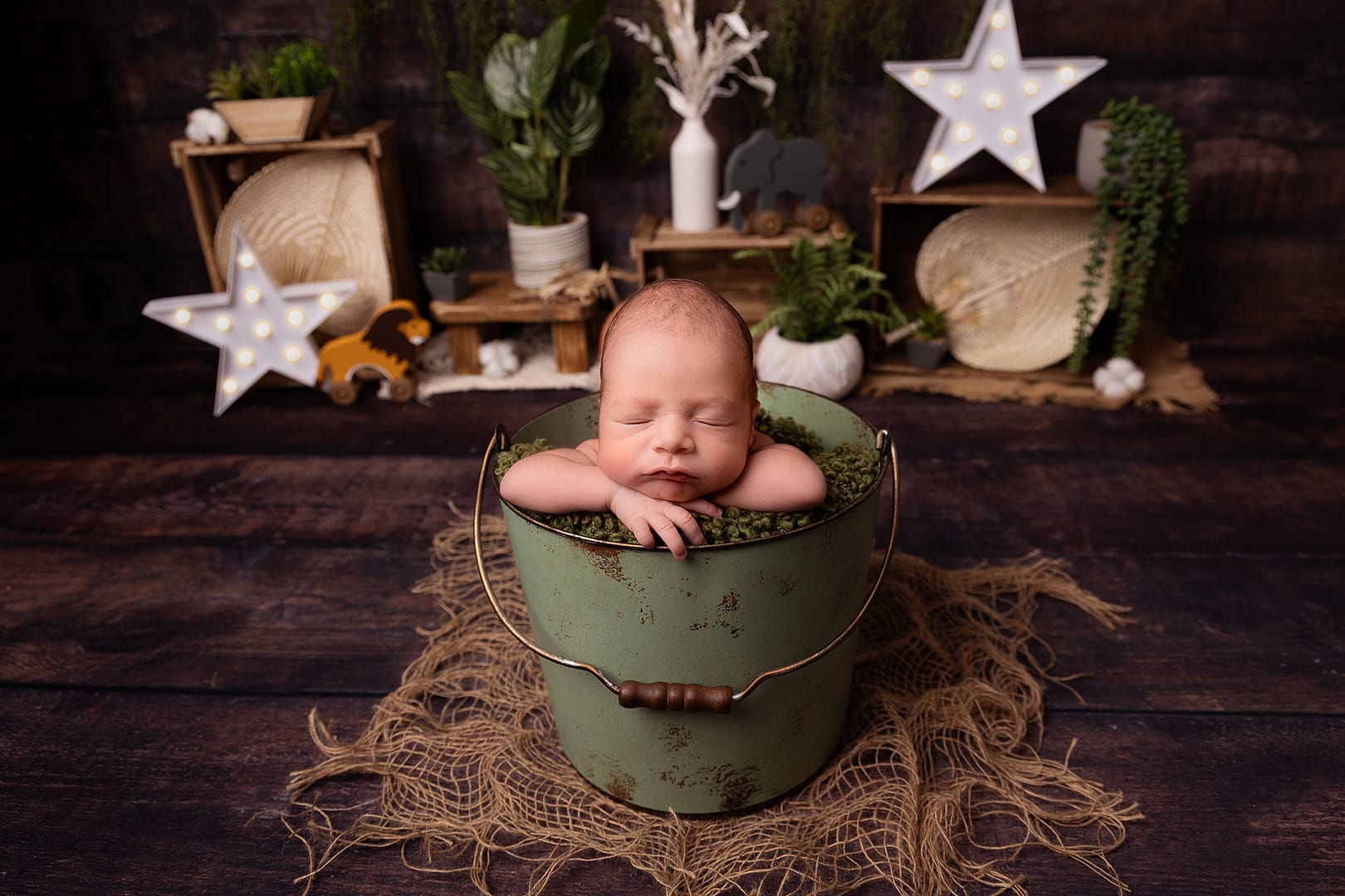 newborn boy posed in a green bucket with a natural boho set up, images taken by newborn photographer Nicki Byrne Photography, newborn photographer birmingham