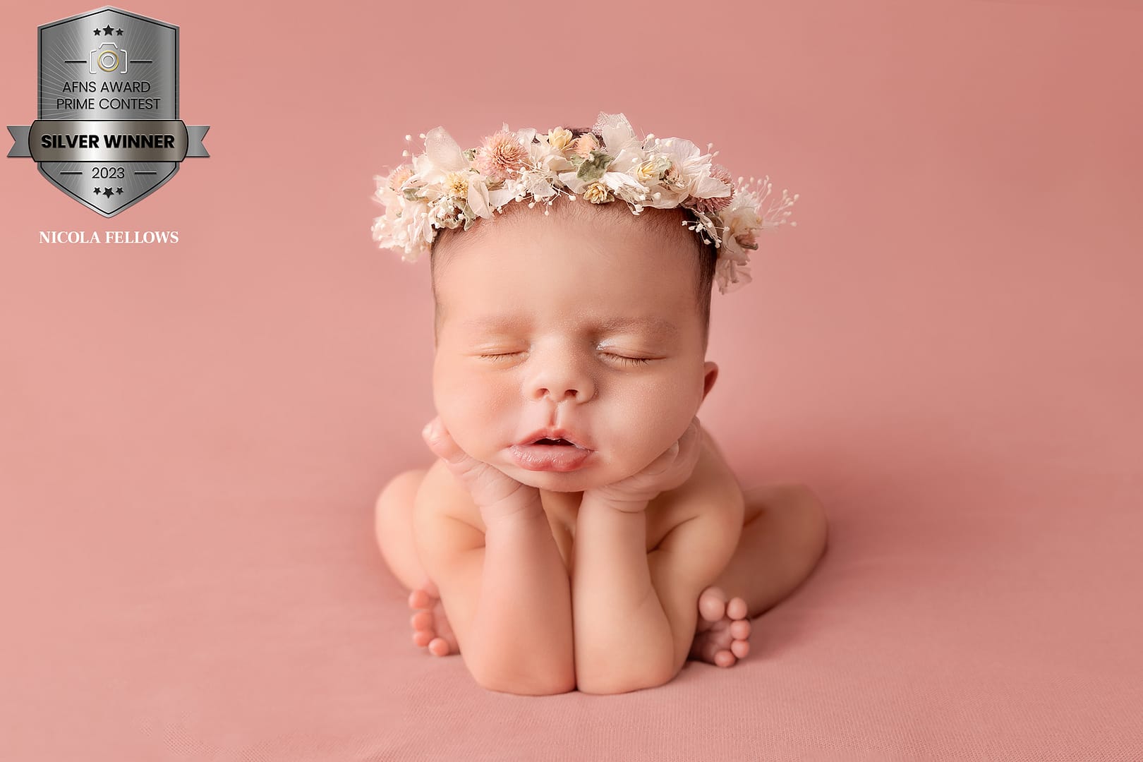 newborn baby girl posed in a froggy position with a floral headband on.  Taken by newborn photographer Nicki Byrne Photography, newborn photographer birmingham