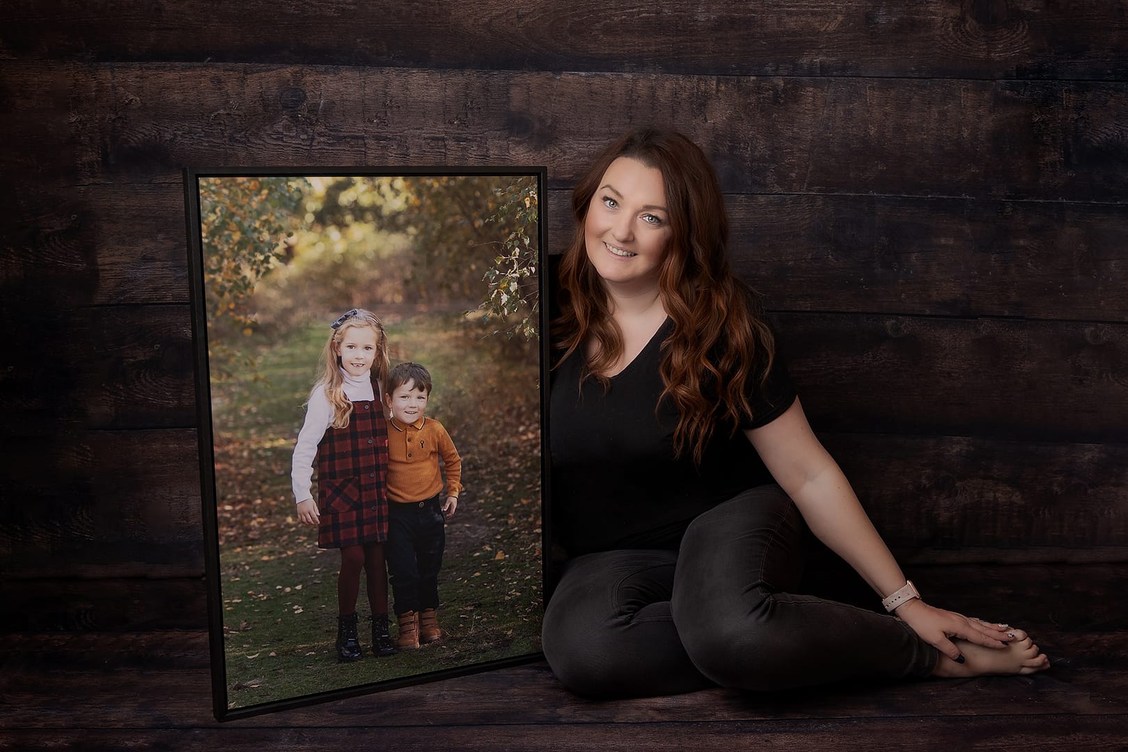 family photographer from Sutton Coldfield Birmingham holding a beautiful piece of wall art of two gorgeous children