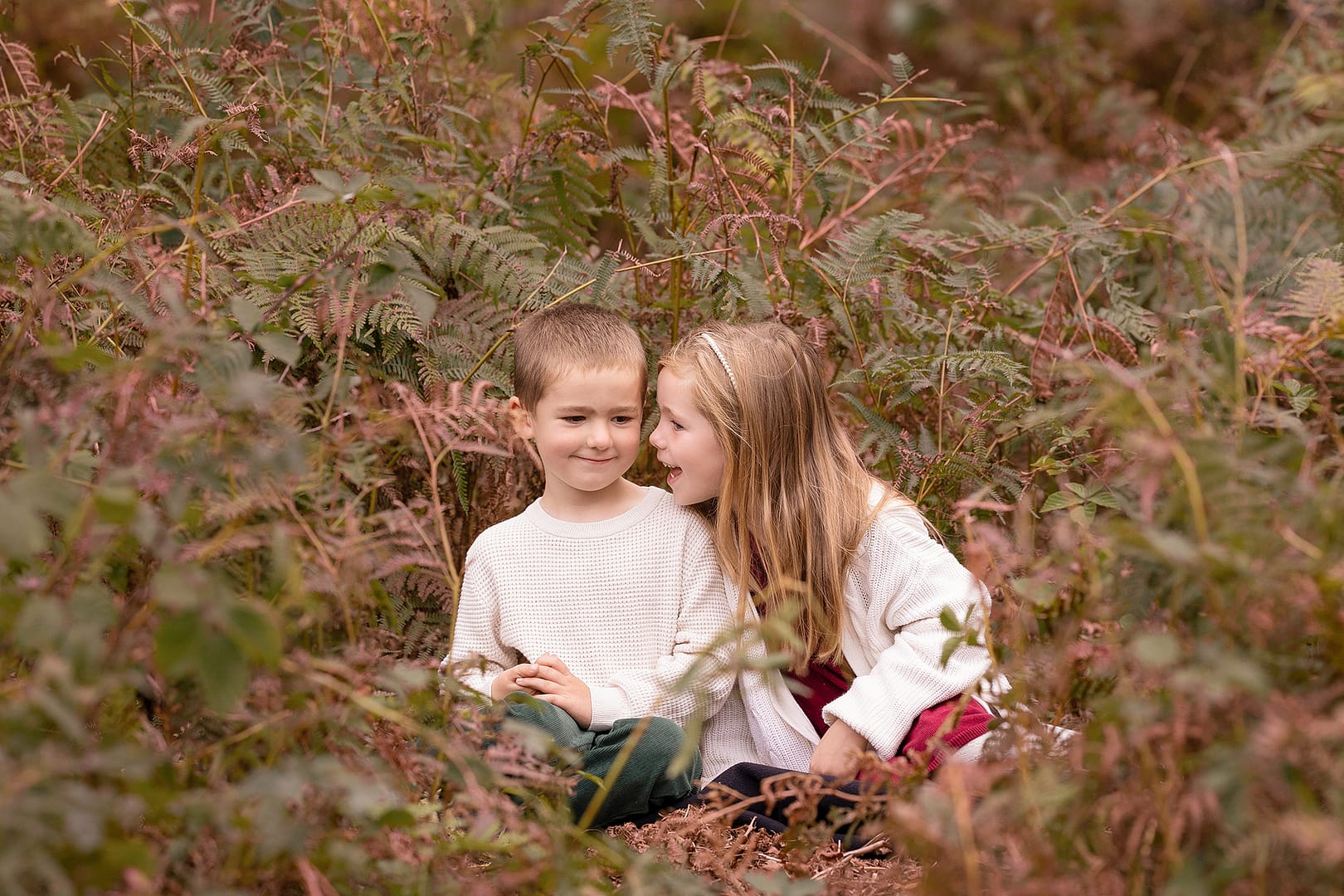 Brother and sister  sat outdoors at Sutton Park amongst the ferns.  Taken by family photographer Nicki Byrne Photography, Sutton Coldfield Birmingham
