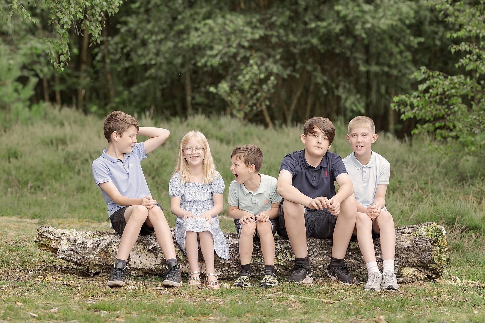 Kids being kids - sat on a log during the summer time for their outdoor photoshoot in the park.  Laughing, having fun and being themselves.  Captured by Family photographer Nicki Byrne Photography, Sutton Coldfield Birmingham
