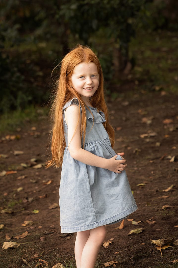 Beautiful red haired girl posing naturally and smiling for Sutton Coldfield's family photographer Nicki Byrne Photography, family photographer Sutton Coldfield birmingham