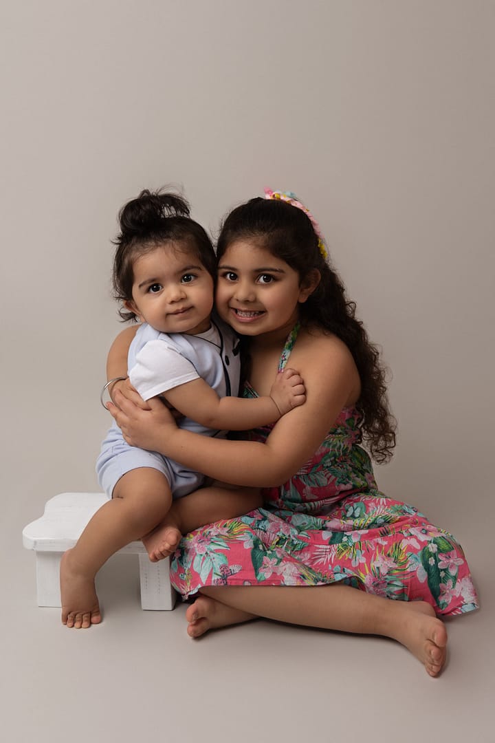 Brother and sister posing for a photo in the Sutton Coldfield Studio, taken by Nicki Byrne Photography, Family photographer Sutton Coldfield birmingham