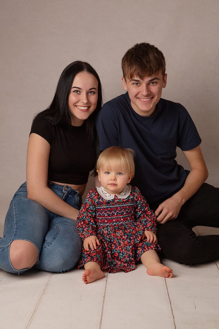 Baby girl who has just turned one, celebrating at her cake smash in Sutton Coldfield Birmingham with her older brother and sister