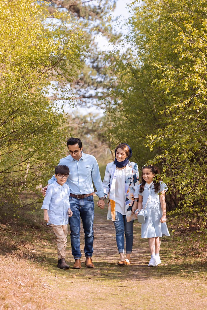 outdoor photograph, family walking through the park surrounded by trees. family all talking. Taken by family photographer sutton coldfield birmingham