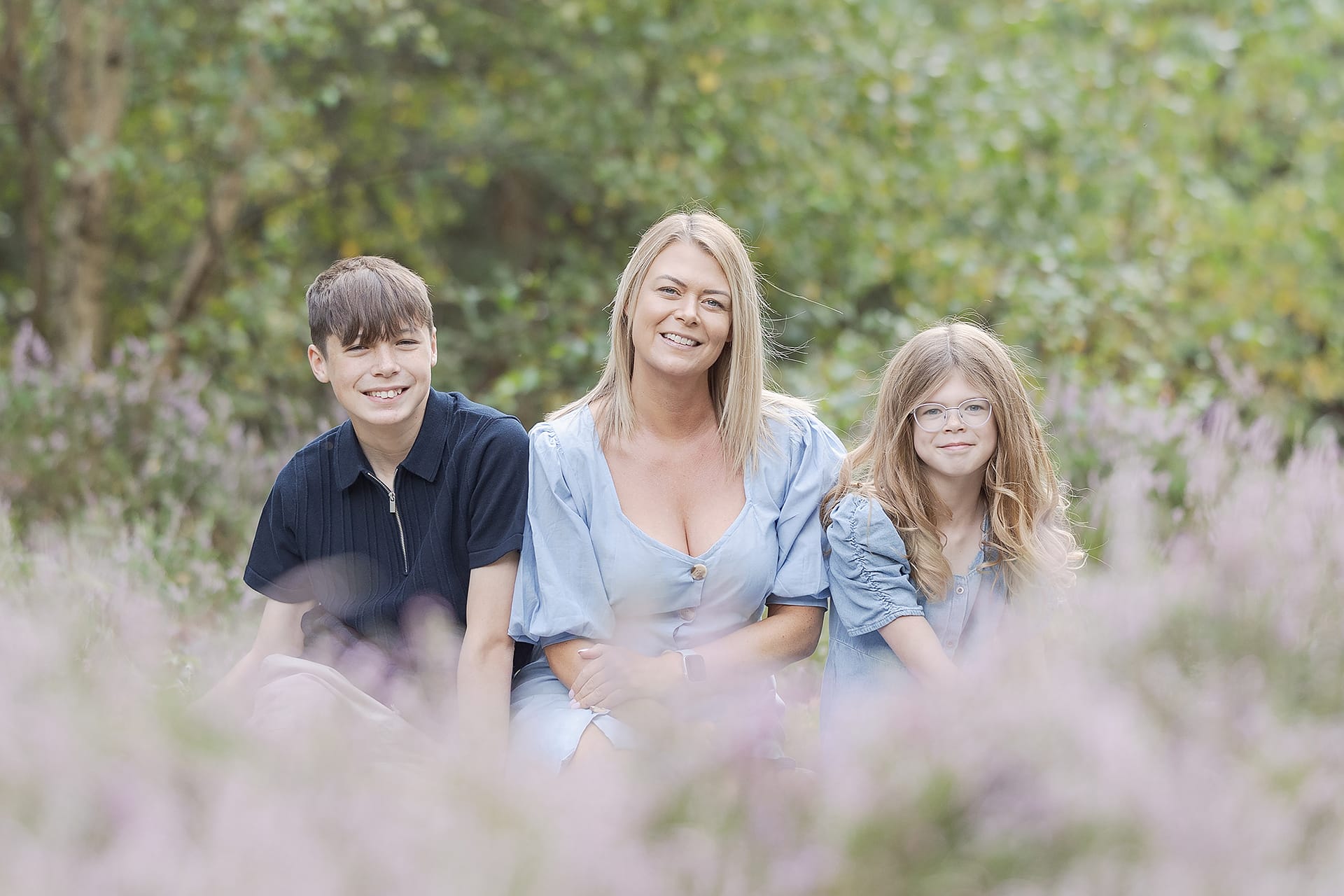 Family of three - Mom, Son and daughter - sat amongst the purple heather